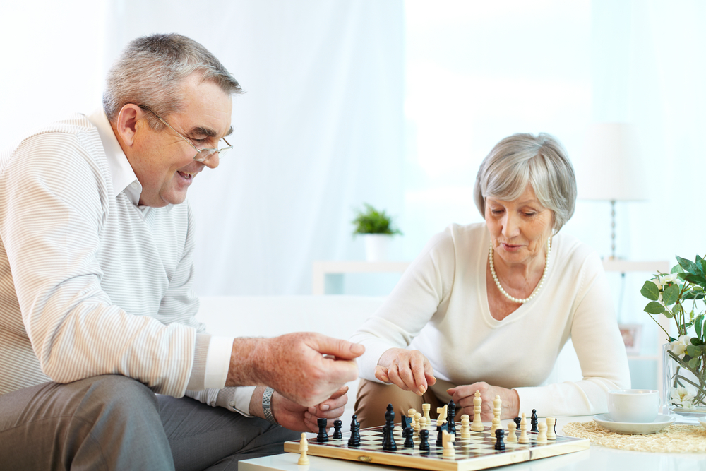 A senior man and woman playing a game of chess. Board games are one strategy to help keep the mind active and agile.