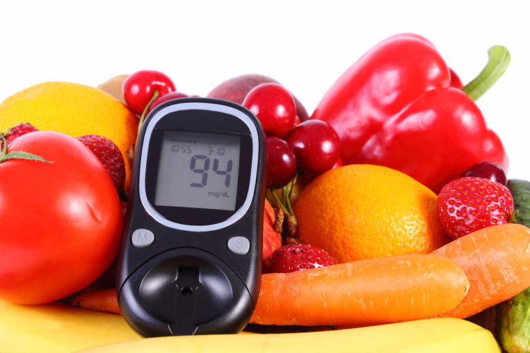 Fruit and vegetables and a glucose monitor. Lifestyle and diet modifications can make living with diabetes more manageable.